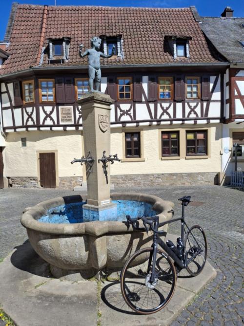 Ein Rad lehnt an einem Brunnen vor einem Fachwerkhaus. (c) Frank Klemm Ein Rad lehnt an einem Brunnen vor einem Fachwerkhaus.